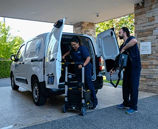 A dentist and dental assistant offload the dental equipment from the MDCA van