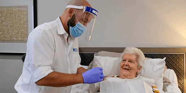 A dental prosthetist holds a newly made denture to be inserted