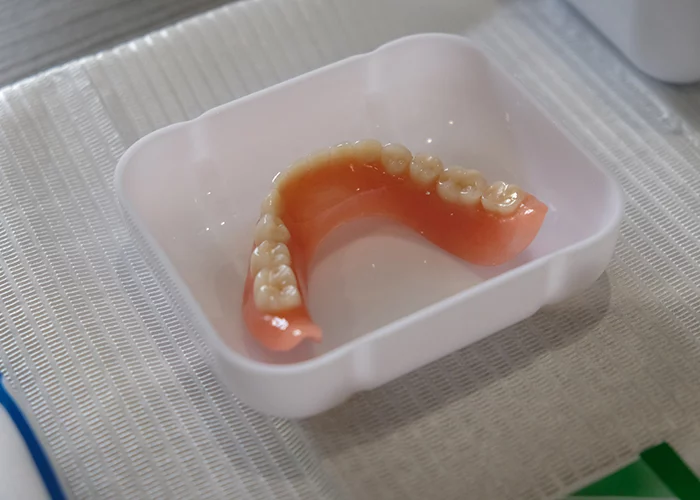 Complete lower denture in a denture bath