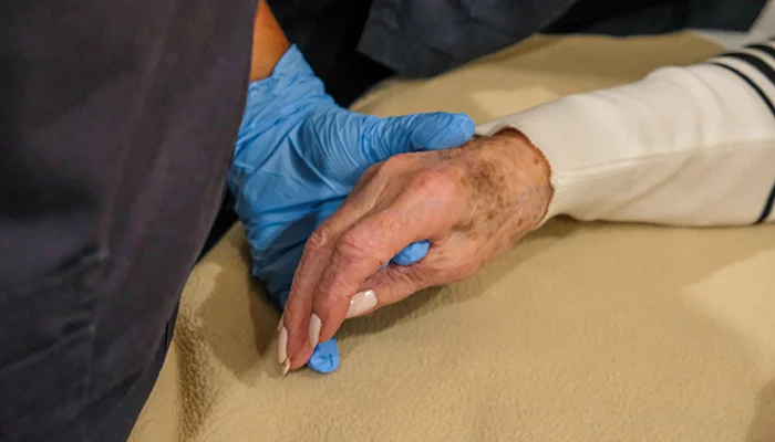 Dental prosthetist holding an elderly patient's hand